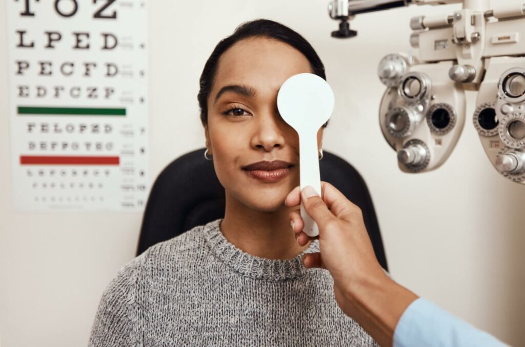 Patient undergoing an eye examination with an eye chart and diagnostic equipment