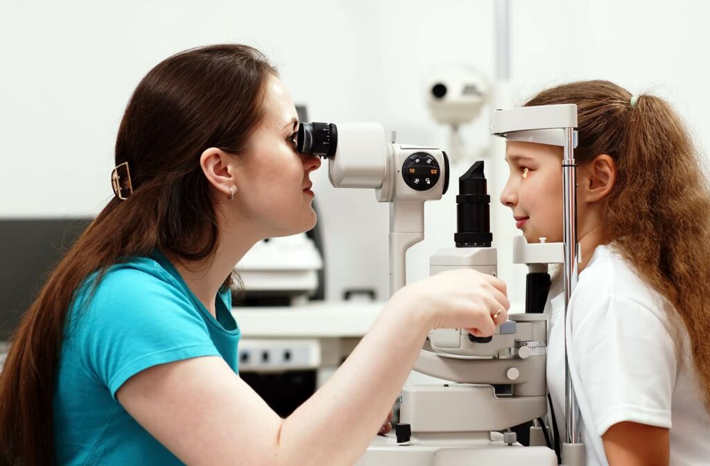 An eye doctor uses a slit lamp to perform a child's eye exam.