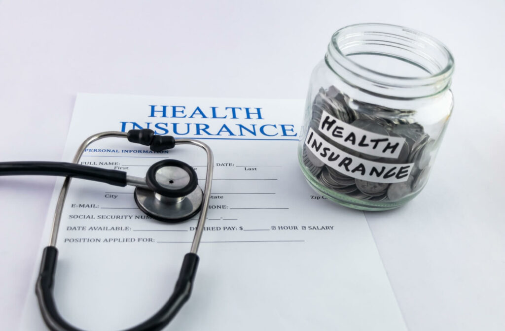 A health insurance form, a stethoscope, and a coin jar